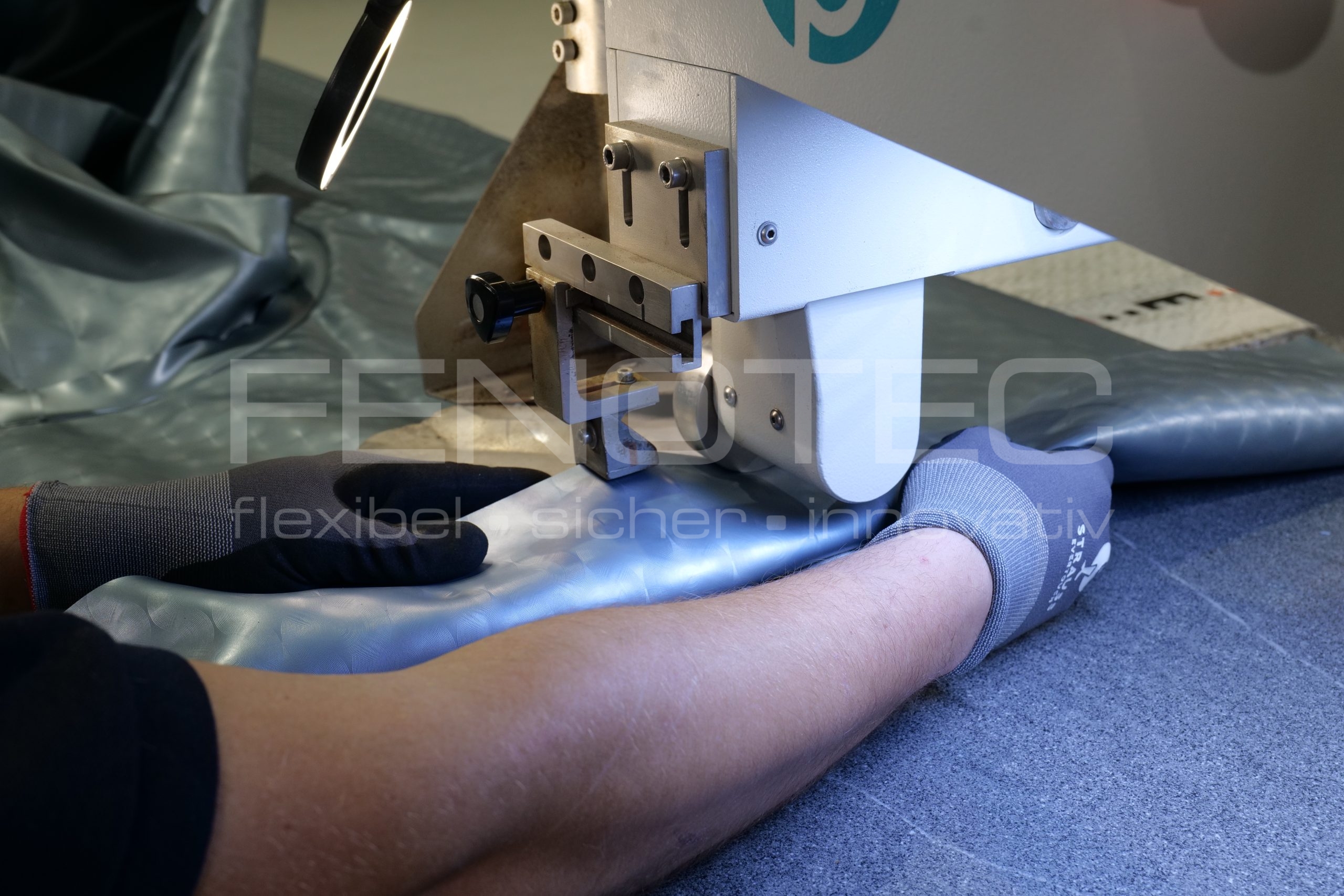 ein Maschine kontrollierender Mitarbeiterarm neben Heizkeil-Maschine